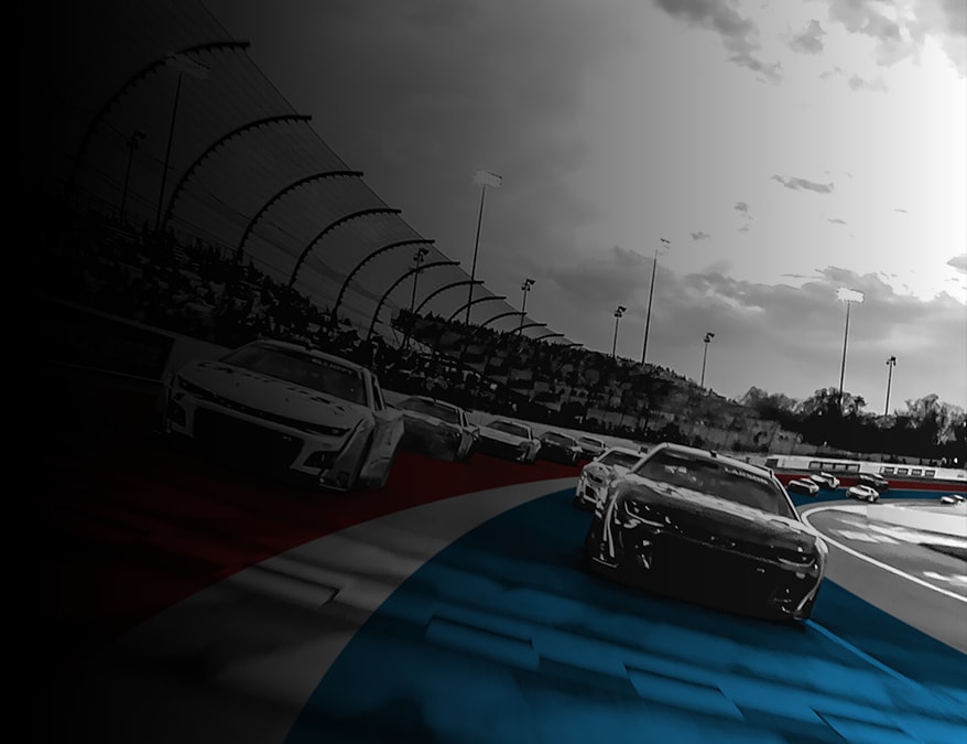 UTI trade school graduate wearing a black cap and gown with honor cords, smiling at commencement ceremony.