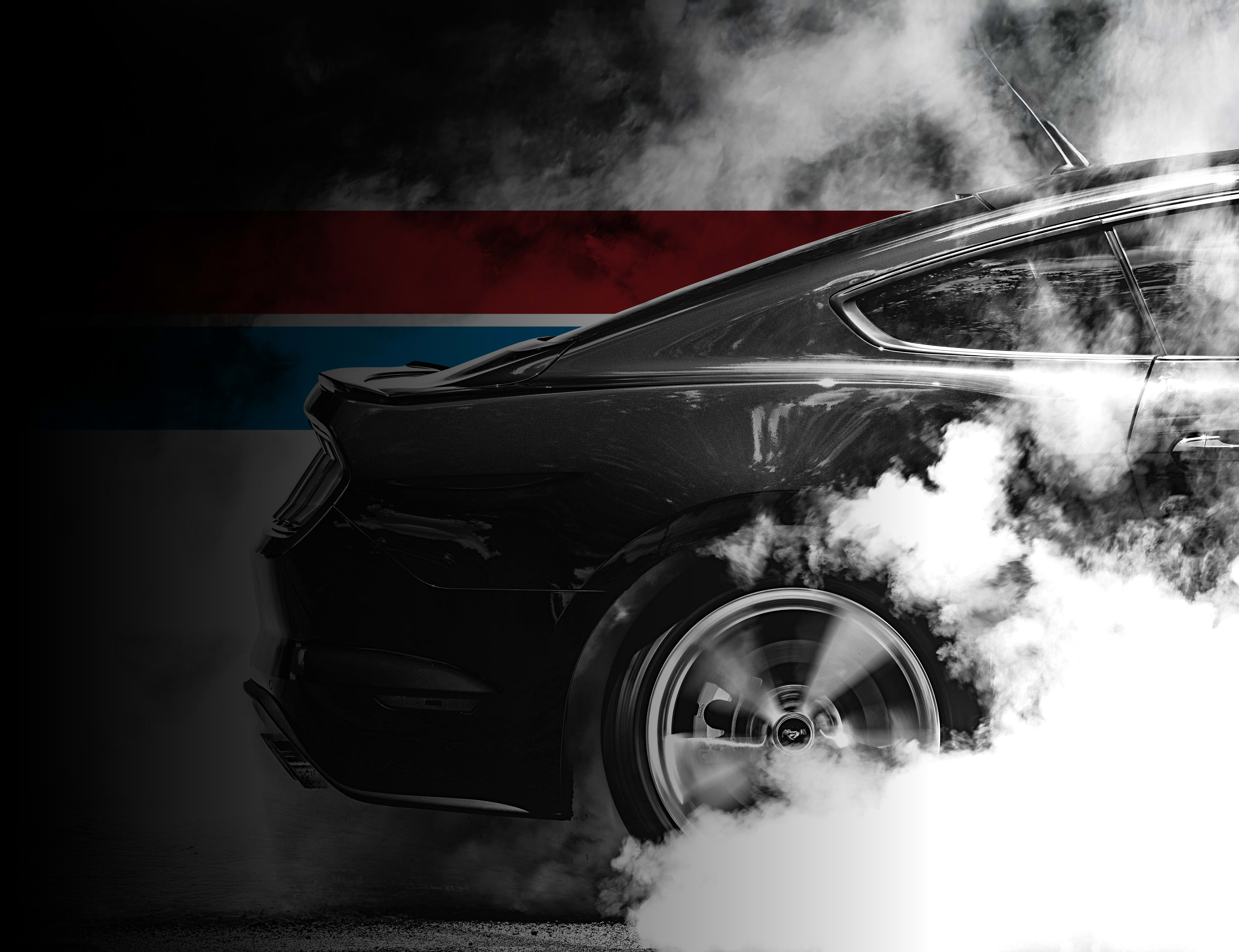 UTI trade school graduate wearing a black cap and gown with honor cords, smiling at commencement ceremony.