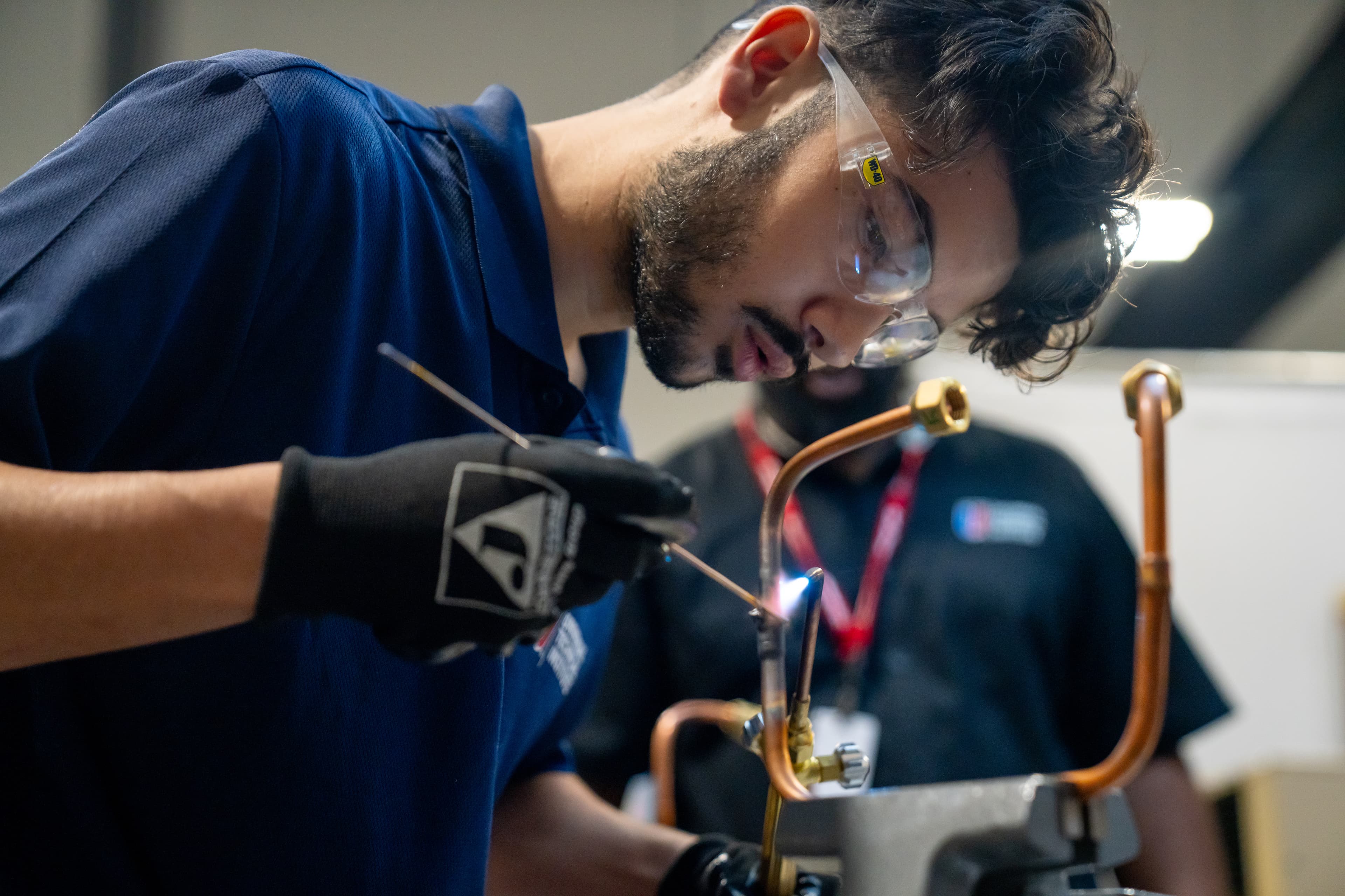 UTI student inspects and tests a heavy-duty diesel engine on a white semi.